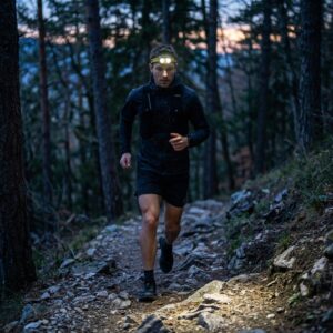 Corredor de trail running con la frontal Nitecore UT27 encendida en un sendero de montaña al anochecer